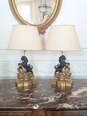 two lamps sitting on a table with a mirror in the background