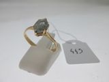 l'image d'une bague en or ornée d'une pierre verte