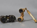 une paire de jumelles anciennes et un télescope posés sur une table