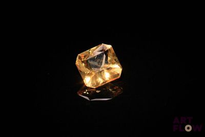 gros plan d'un diamant jaune sur une surface noire