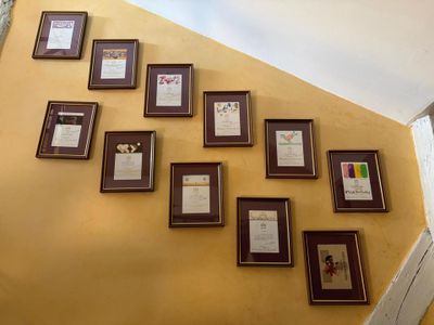 many framed pictures on the wall of this room