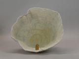 a white bowl that has a small wooden handle in it