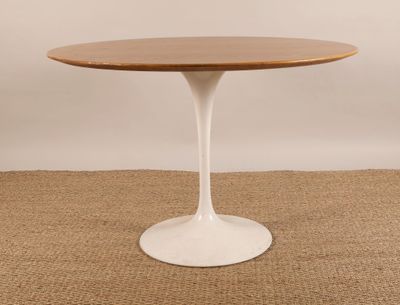 une table ronde avec un plateau en bois et un piètement blanc