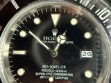 a rolex watch with a black dial on a brown leather strap