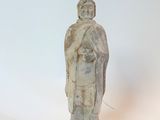 une petite statue représentant un homme debout sur une surface blanche