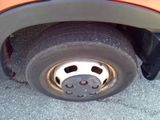 a close up of a flat tire on an orange truck