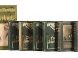 several old books are lined up in a row on a white surface