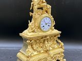 une horloge en or surmontée d'une statue