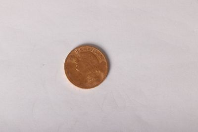 a close up of a penny sitting on top of a white surface