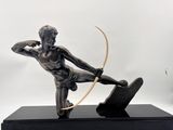 statue en bronze représentant un homme muni d'un arc et de flèches, posée sur un socle noir
