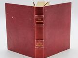 an open red book with two books on top of it