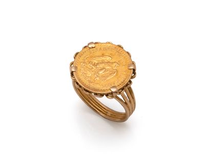 Gros plan sur une bague en or ornée d'une pièce de monnaie
