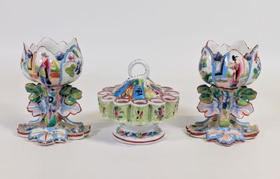 trois vases de couleurs différentes, ornés de fleurs, posés sur une surface blanche