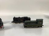 three toy trains that are sitting on a white surface