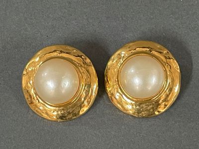 two pairs of gold and pearl earrings on a gray surface