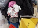a pile of clothes in a plastic bag on a bed