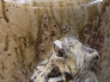 a close up of a vase with a cat on it