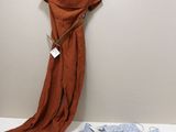 une robe marron accrochée au mur à côté d'un jean