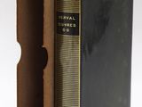 an old book with a black cover sitting inside of it