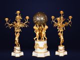 trois statues dorées et blanches surmontées d'une horloge