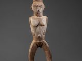 an old wooden statue of a man with his arms crossed
