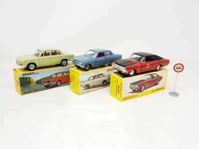 four toy cars are lined up in a row on a white surface