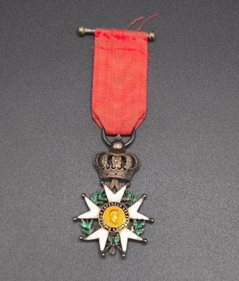 an image of a medal with a red ribbon on a black surface