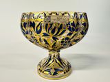 a blue and gold vase with a plaque on it