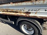 a rusted truck parked on the side of the road