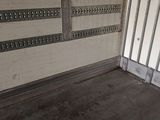 a small room with a metal door and a window