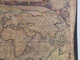 an old map of the world is displayed on a table