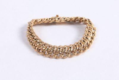 gros plan d'un bracelet en chaîne en or sur une surface blanche