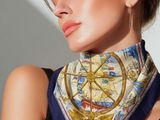 the woman is wearing a scarf with an image of a ship on it