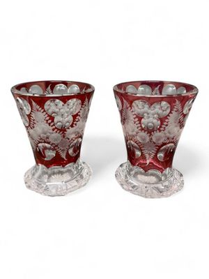 pair of red glass vases sitting on top of a white surface