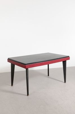 une photo d'une table basse noire et rouge aux pieds noirs