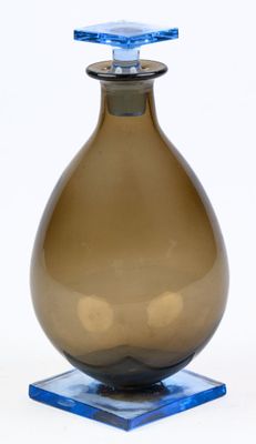 a brown glass vase with a blue top on a blue base