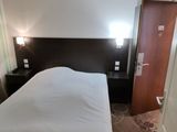 a bed that is in a small room with a big bed