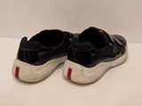 black and white sneakers with red stripes on them sitting on a white surface