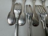 five forks and six spoons sitting on a table