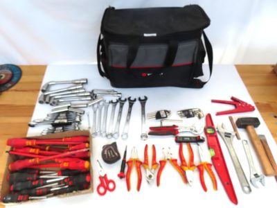 un sac d'outils posé sur une table à côté d'une paire de ciseaux