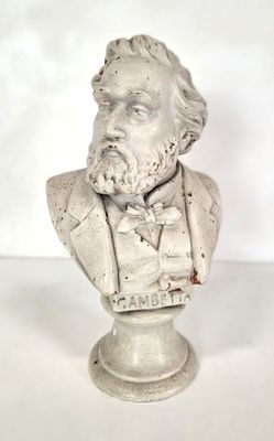 statue représentant le buste d'un homme portant un nœud papillon, posée sur un socle