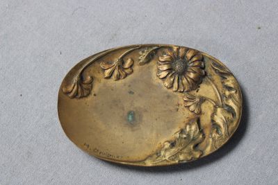 une plaque ancienne en laiton ornée de fleurs et de feuilles