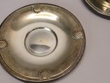 a silver plate with a candle on it on a table