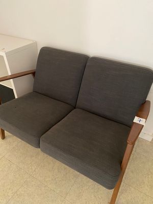 un canapé gris avec un accoudoir en bois dans une pièce