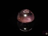 sphère de quartzite violette sur une surface noire avec reflet