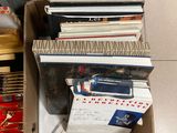 a box full of books on the floor next to a chair