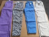 Plusieurs pantalons de différentes couleurs sont alignés sur une boîte en carton