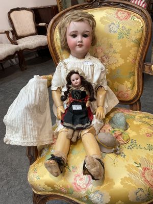 une poupée assise sur une chaise dans une pièce