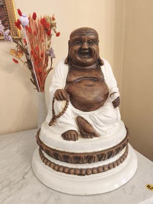 a statue of a laughing buddha sitting on a table