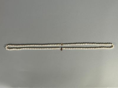 a close up of a white beaded bracelet with a gold clasp